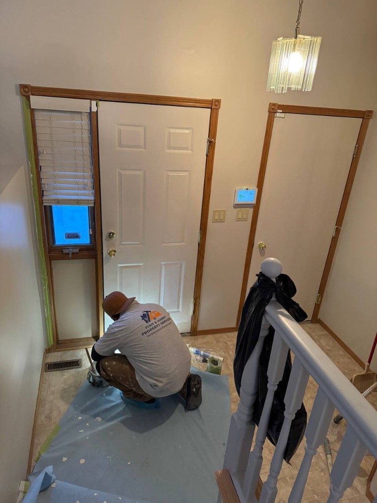 Installer working on a ceiling with tools and tool belt.